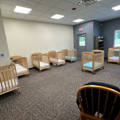 Cribs and rocking chair in the infant room of the Foundations Community Childcare daycare center